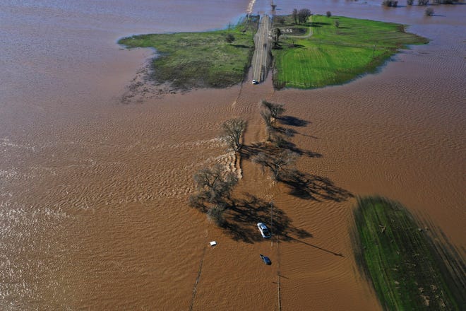 Three vehicles are submerged on Dillard Road west of Highway 99 in south Sacramento County in Wilton, Calif., on Jan. 1, 2023, after heavy rains on New Year's Eve produced levee breaks.