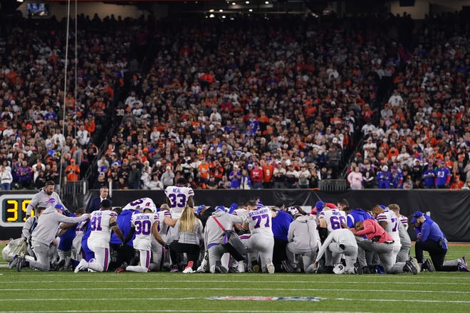 Buffalo Bills players huddle and pray after teammate Damar Hamlin #3 collapsed on the field after making a tackle against the Cincinnati Bengals during the first quarter at Paycor Stadium on January 02, 2023 in Cincinnati, Ohio.