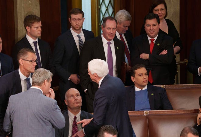 Rep. George Santos, R-N.Y., in the blue sweater, at the start of the session of Congress on Jan. 3, 2023.