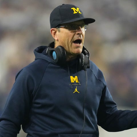 Michigan head coach Jim Harbaugh gestures from the