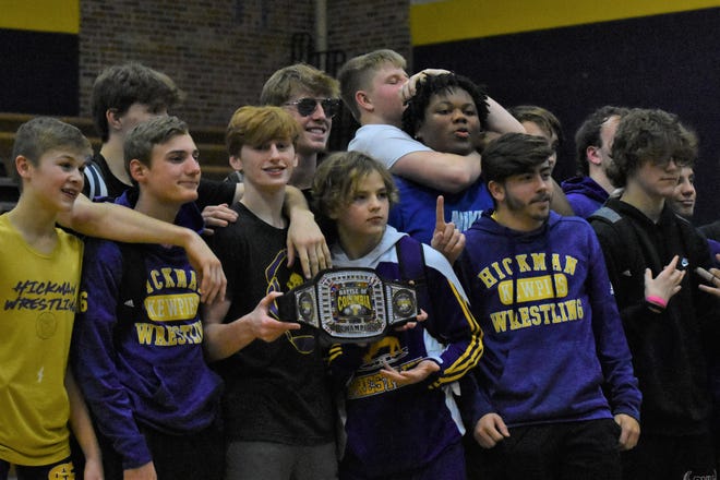 The Hickman boys wrestling team poses with the Battle for the Belt championship belt on January 3, 2022, at Hickman High School. The Kewpies have won the belt four seasons in a row.