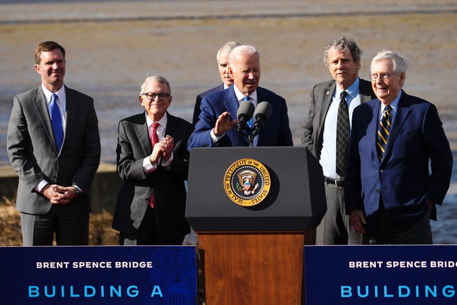 De izquierda a derecha: el gobernador de Kentucky, Andy Beshear, el gobernador de Ohio, Mike DeWine, el exsenador de Ohio, Rob Portman, el senador de Ohio, Sherrod Brown, y el senador de Kentucky, Mitch McConnell, escuchan al presidente Joe Biden promocionando una inversión federal de $1600 millones en la tan esperada mejora del puente Brent Spence. Miércoles, 4 de enero de 2023, en Covington, Ky.