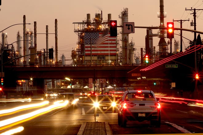 Traffic streams past the Marathon Refinery on Oct. 4, 2022, in Carson, California. The state's push toward clean energy creates doubt about the future of its oil and gas workers.