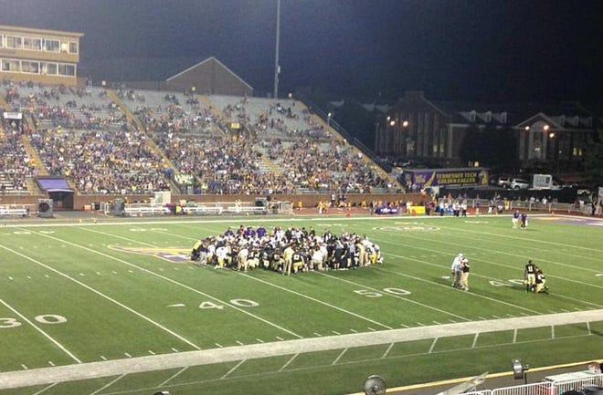 Wofford and Tennessee Tech football teams huddle in prayer in the 2016 season opener after Terriers linebacker Michael Roach suffered cardiac arrest.