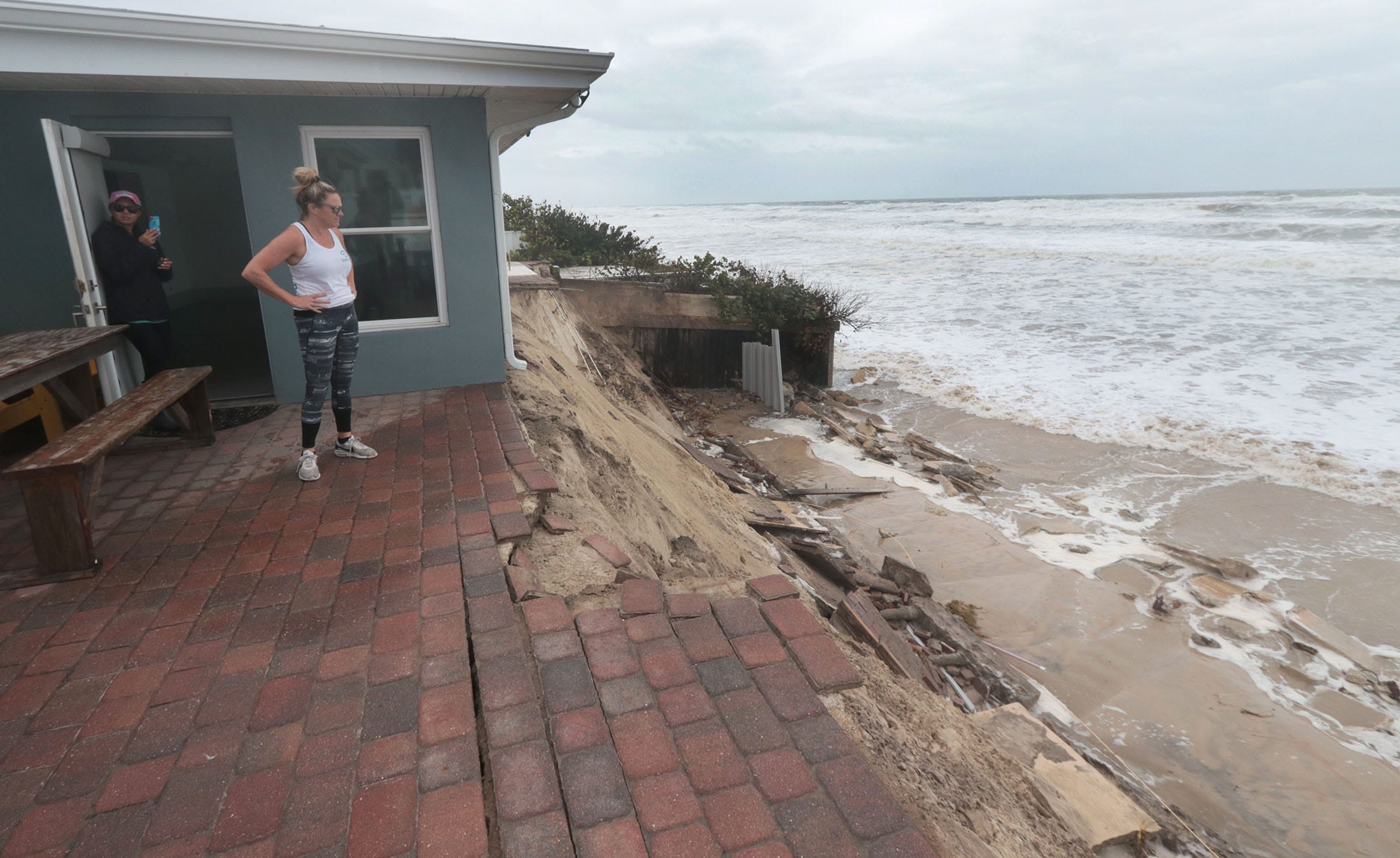 Krista Goodrich, Property manager for Salty Dog Vacations, looks at the ocean as it slowly eats away at the already damaged dune from Hurricane Ian, at 4115  South Atlantic Avenue in Wilbur-by-the-Sea, Wednesday November 9, 2022 as Tropical Storm Nicole threatens more damage.