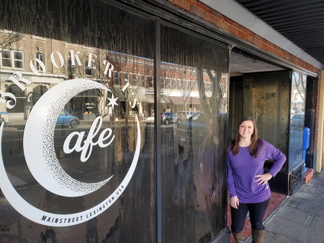 Brooke Bishop, who owns Brooker T's Café with her mom, Tammy Cornell, in uptown Lexington, stands outside the restaurant's soot-covered windows. She said the restaurant, which was destroyed by fire in September 2022, will reopen.