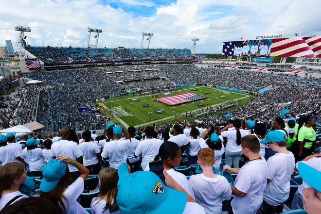 A large American flag is unfurled on the TIAA Bank field before the start of a Nov. 6 game between the Jaguars and the Baltimore Ravens. The Jaguars and the city are working on plans for an extensive renovation of the stadium with a new roof over it. If done, it would be the most expensive civic construction project in Jacksonville history.