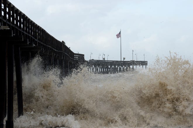 The Ventura Pier gets a thrashing by 20-foot waves during high tide after a storm on Thursday morning.
