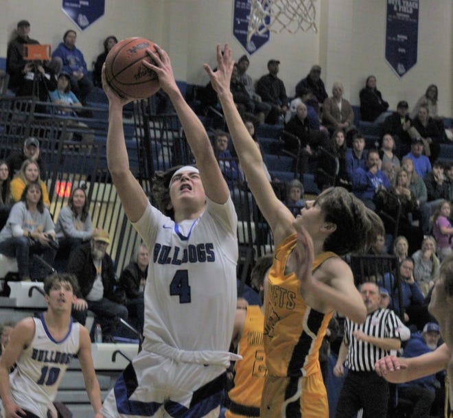 Inland Lakes senior Kaden Hansel (4) goes up strong to the basket while Pellston's Josh Grondin (right) defends during the first half of Thursday's boys basketball contest in Indian River.