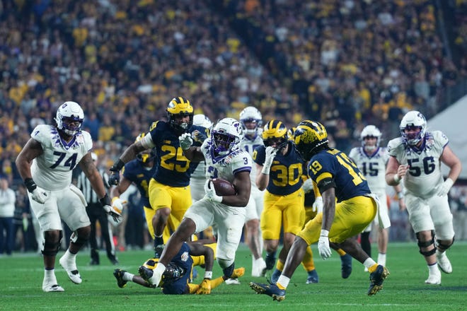 TCU running back Emari Demercado (3) runs with the ball against Michigan during the second half of the 2022 Fiesta Bowl at State Farm Stadium.