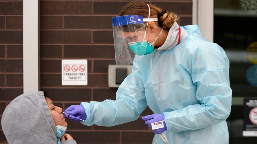 A nurse administers a COVID-19 test outside the Salt Lake County Health Department, Tuesday, Dec. 20, 2022, in Salt Lake City.