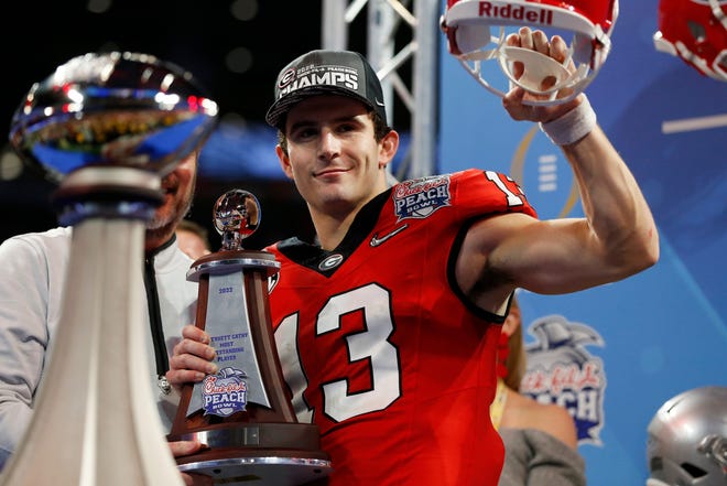 Georgia quarterback Stetson Bennett (13) celebrates with the offensive MVP trophy after winning the Chick-fil-A Peach Bowl NCAA College Football Playoff semifinal game between Ohio State and Georgia on Sunday, Jan 1, 2022, in Atlanta. Georgia won 42-41.

News Joshua L Jones