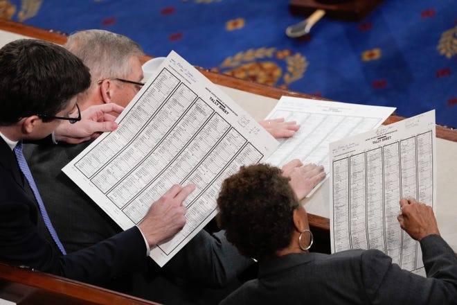 Congressional staffers check the vote tally on the 15th ballot for speaker of the House of Representatives on Saturday Jan. 7, 2023.