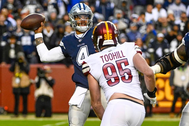 Dallas Cowboys quarterback Dak Prescott (4) looks to pass as Washington Commanders defensive end Casey Toohill (95) closes in on him during the first half at FedExField.