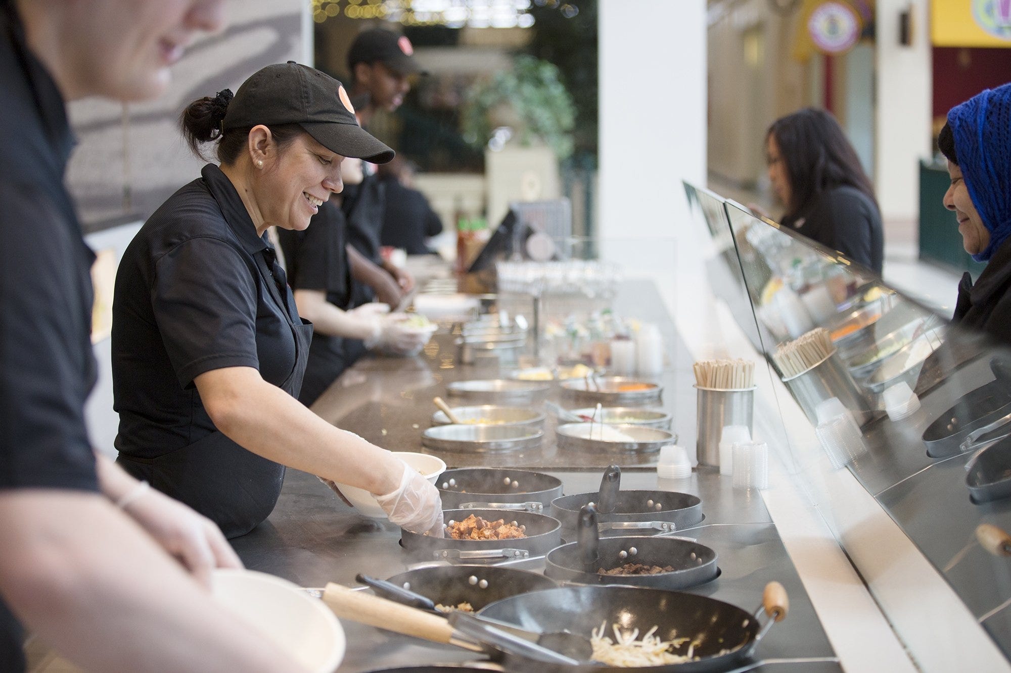 Assistant manager, Maria Sigala, helps a first time customer at BiBiBop's flagship location inside Easton Town Center, Tuesday, April 7 2015.  (Dispatch Photo by Courtney Hergesheimer) 