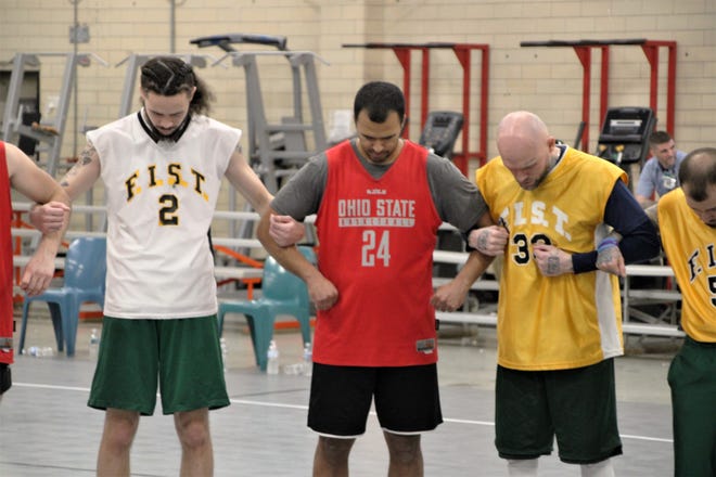 Inmates from Marion Correctional Institution linked arms with members of a basketball team led by former Ohio State standout Aaron Craft to pray following a game played Jan. 3, 2023, at the prison. The game is part of the Faithful In Serving Together (FIST) ministry, founded by Marysville resident Kent Money, which provides outreach programs to prisons. Money has the program operating in six prisons in Ohio and hopes to add more soon.