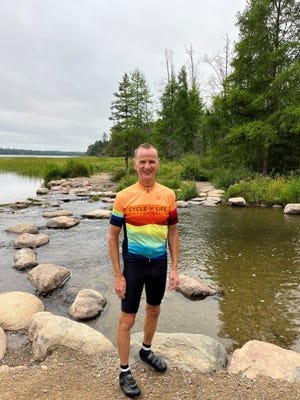 Roger Gray, of Rice Lake, Wis., is pictured at the headwaters of the Mississippi River as it begins to flow out of Lake Itasca in northern Minnesota. Gray biked the length of the river last summer.