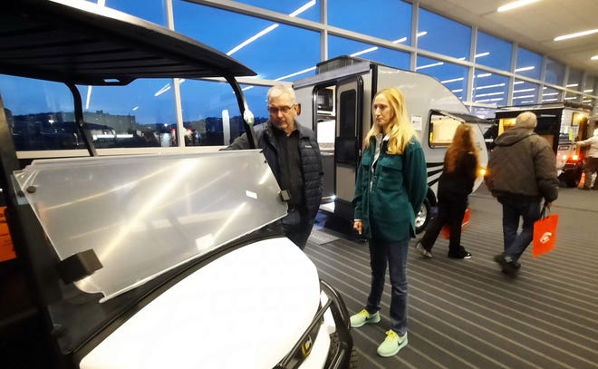 Rick and Jen Carlson of Bridgeville look at a golf cart Tuesday at the Pittsburgh RV Show.  Many campers use golf carts to travel around their campsites.