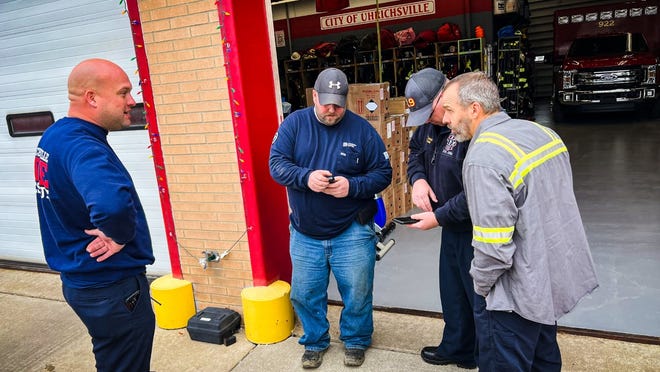 Uhrichsville Fire Chief Justin Edwards, a representative of Dominion Energy, Uhrichsville Fire Capt. Nathan Crouse and Mike Swick, a contractor from Northeast Ohio Natural Gas Corp., (left to right) discuss the strong natural gas odor Wednesday across Tuscarawas County.