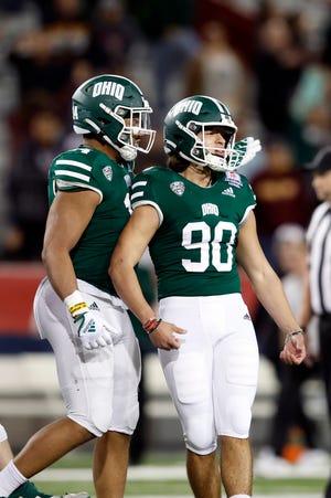 Tight tackle Bryce Butler reacts with center fielder Nathaniel Vacus (90) of the Ohio Bobcats after Vacus kicks the game-tying goal during the second half of the Barstool Sports Arizona Bowl against the Wyoming Cowboys at Arizona Stadium on December 30, 2022 in Tucson, Arizona.