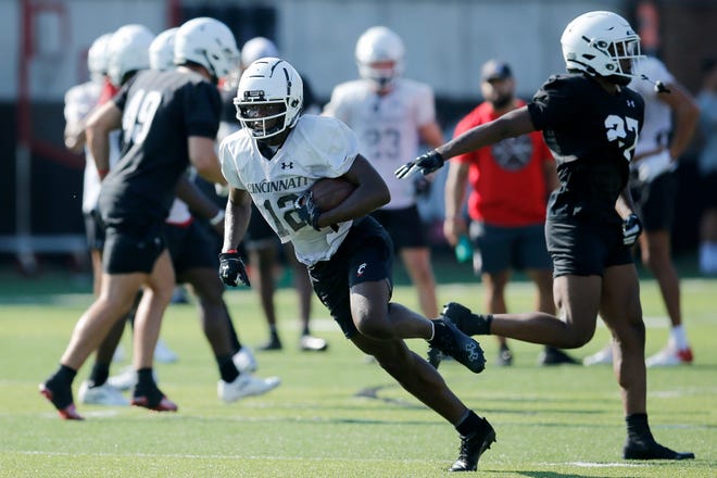 Bearcats receiver Quincy Burrows (12) works with a catch during the first day of preseason training camp at the University of Cincinnati's Sheckley Sports Complex in Cincinnati on Wednesday, Aug. 3, 2022.