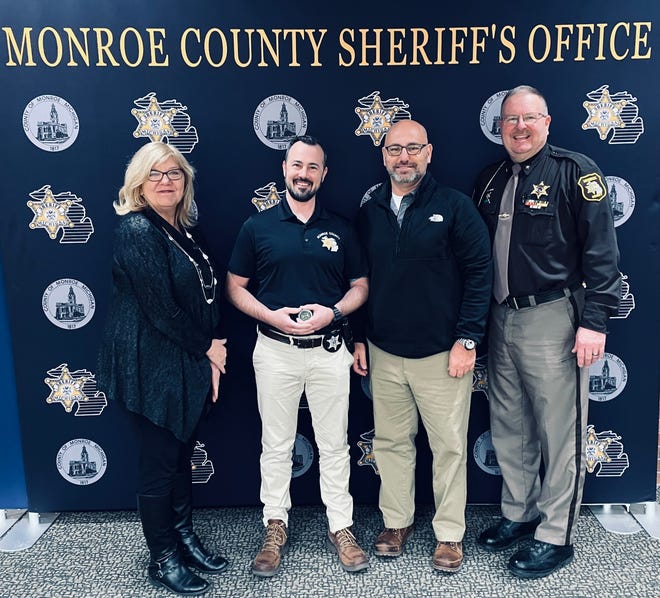 Detective Patrick Davison of the Monroe County Sheriff's Office (second from left) holds a challenge coin from Gov. Gretchen Whitmer that was presented to him for his work to investigate the death of a local dog who was poisoned. Also pictured (from left) are Michigan Department of Agriculture and Rural Development Acting Director Kathy Angerer, Detective Sgt. Mike Preadmore and Sheriff Troy Goodnough. MDARD started the investigation.