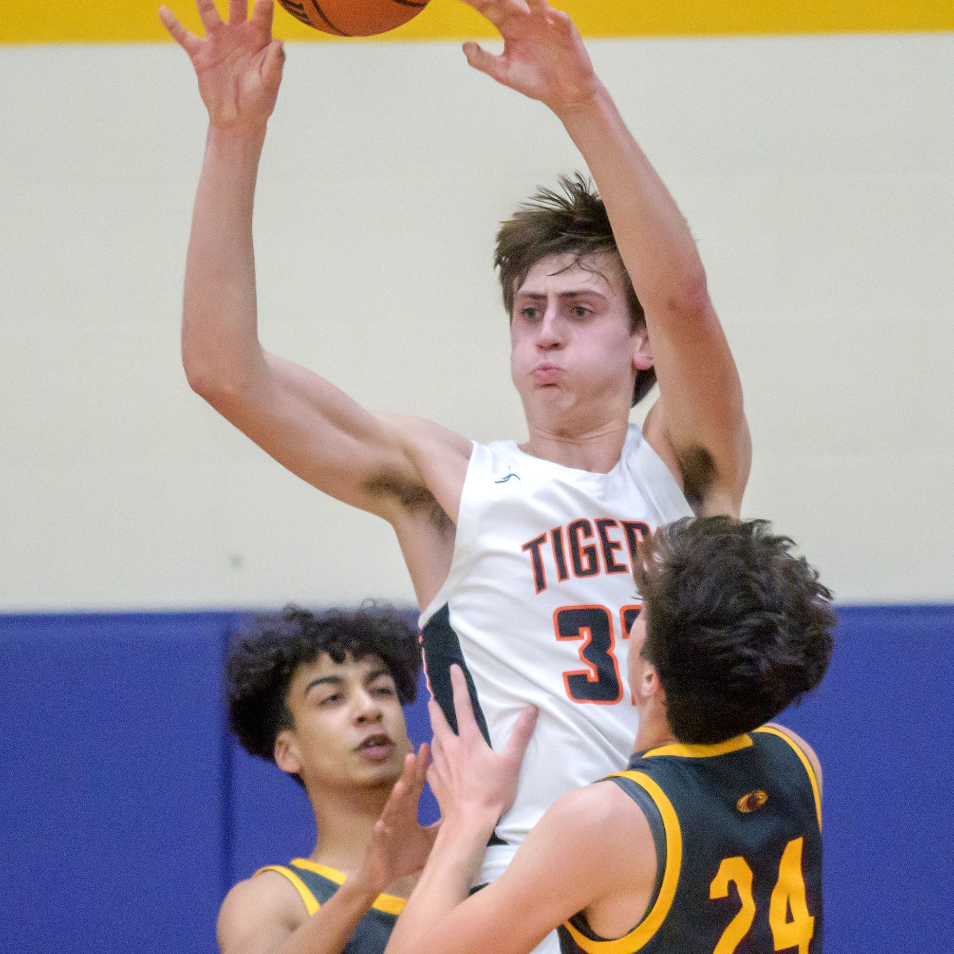 Illini Bluff's Hank Alvey (32) passes to a teammate under pressure from ROWVA Wethersfield's Riley Danner (24) and Devante Noel during their ICAC Tournament semifinal Thursday, Jan. 12, 2023 at Peoria Christian High School in Peoria. The Tigers advanced to the title game with a 61-34 victory over the Cougars.