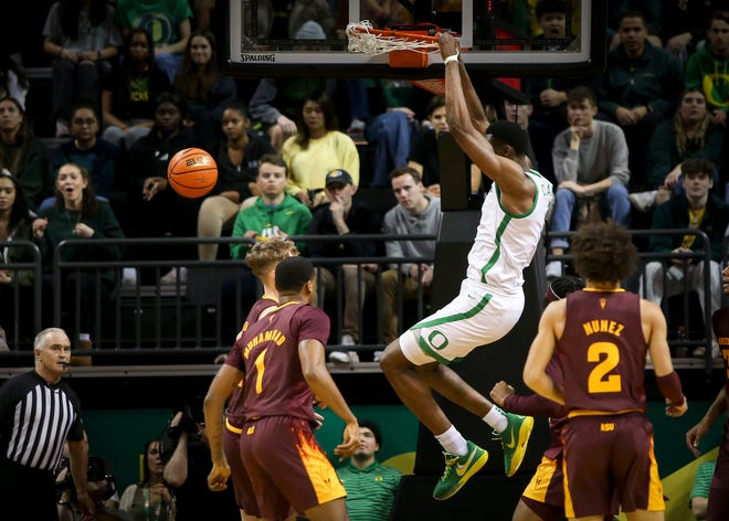 Oregon center N'Faly Dante hangs from the rim after a dunk as the Oregon Ducks host the Arizona State Sun Devils Thursday, Jan. 12, 2023, at Matthew Knight Arena in Eugene, Ore.