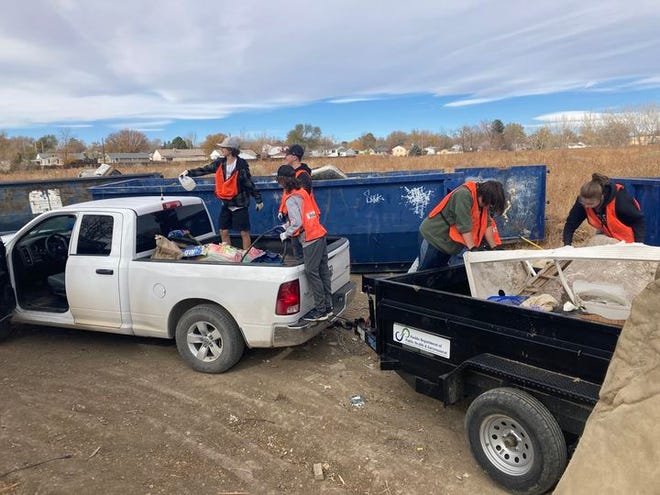 Volunteers with the Pueblo City County Trash Task Force pick up trash during a clean-up event.