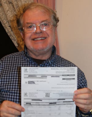 Dr. Darrell Durbrow holds the water bill in Fort Smith he received for over $120,000. The bill was a mistake.