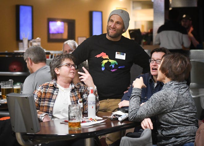 GAAY Sports organizer Nicholas Wendling, 42, middle, of Lansing, chats with attendees at the league's bowling event Thursday, Jan. 12, 2023, at Spare Time Entertainment Center in Lansing. The LGBTQ-centered sports league has various sporting events for the LGBTQ community and its allies.