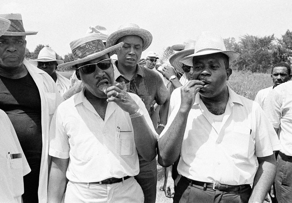 Dr. Martin Luther King bites into a chip of ice as he leads a march of several hundred persons along U.S. 51 near Senatobia on June 9, 1966. The march on was conducted along a hot, sun-parched section of the Memphis-to-Jackson highway.