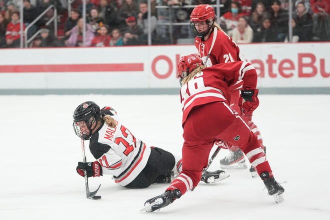 Jan 13, 2023; Columbus, Ohio, USA;  Ohio State Buckeyes forward Emma Maltais (17) takes a behind the back shot as she falls to the ice in front of Wisconsin Badgers forward Casey O'Brien (26) during the NCAA women's hockey game at the OSU Ice Rink. Ohio State won 2-1 in overtime. Mandatory Credit: Adam Cairns-The Columbus Dispatch