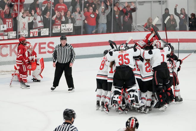 Jan 13, 2023; Columbus, Ohio, USA;  Teammates mob Ohio State Buckeyes defenseman Sophie Jaques (18) after she scored the game-winner in overtime during the NCAA women's hockey game against the Wisconsin Badgers at the OSU Ice Rink. Ohio State won 2-1. Mandatory Credit: Adam Cairns-The Columbus Dispatch