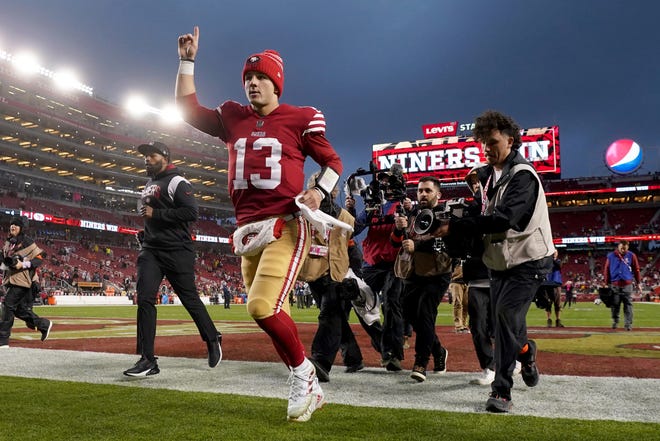San Francisco 49ers quarterback Brock Purdy celebrates as he runs off the field after defeating the Seattle Seahawks.