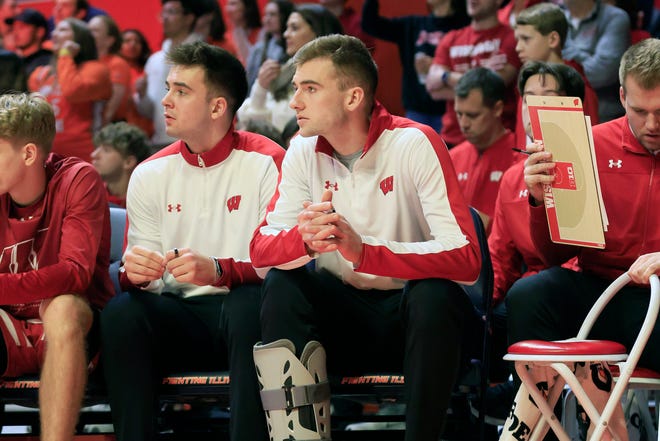 Injured forward Tyler Wahl, right, sits on the Wisconsin bench during the Badgers' loss at Illinois Jan. 7. UW is 0-3 in the three games Wahl has missed with a right ankle injury.