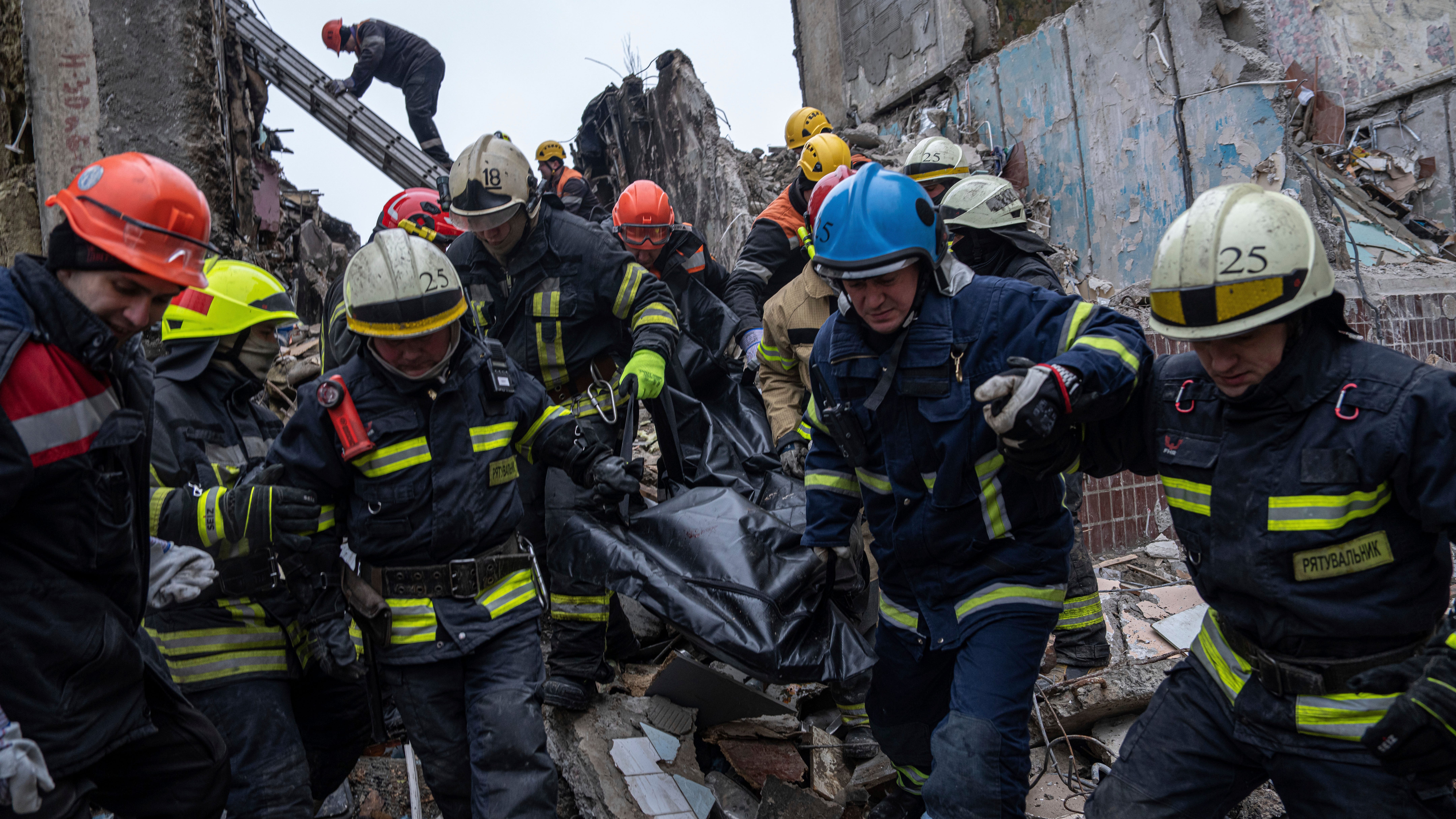 Rescue workers carry the body of a man who was killed in a Russian missile strike on an apartment building in the southeastern city of Dnipro, Ukraine, Monday, Jan. 16, 2023.