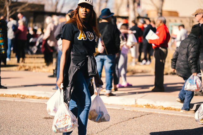 A volunteer from Colorado State University Pueblo participates in a food drive as part of Pueblo's celebration of Martin Luther King Jr. Day on Monday.