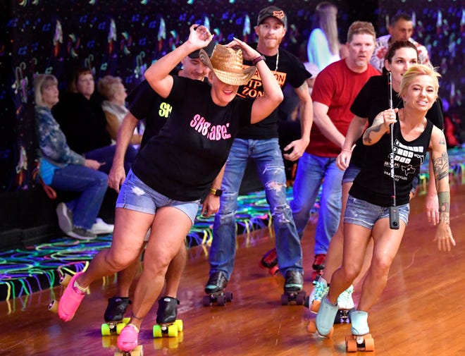 Michelle Webster of Orlando puts on a cowboy hat as she leads a group of shuffle skaters at The Skatin Place Friday. Jen Rankin, also from Florida, shoots TikTok video beside Webster who is one of the more popular TikTok shuffle skate stars and goes by Chellebell,Sk8girl on the platform.