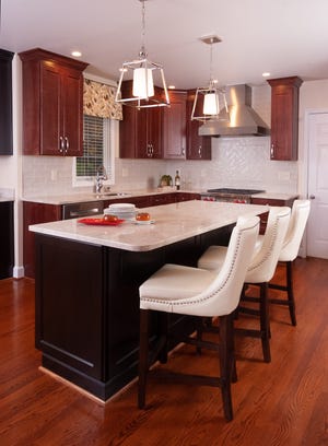 The handcrafted porcelain backsplash provides a light contrast to the dark cabinetry and island.