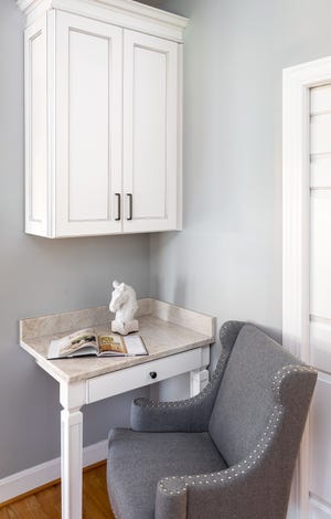 A small desk area sits on the left side of the kitchen, opposite the peninsula.