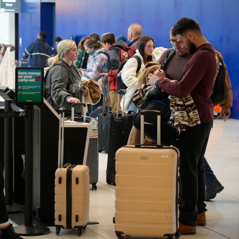 Travelers queue up at the check-in kiosks for Fron