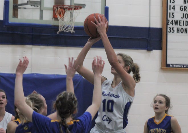 Mackinaw City senior Madison Smith (10) takes a shot over Alanson defenders during the second quarter of Tuesday's girls basketball clash in Mackinaw City.