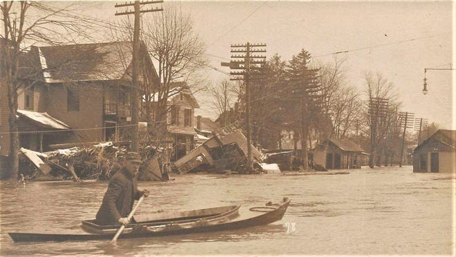 A rescue boat coasts along East State Street after the 1913 flood in Fremont.