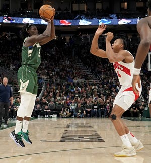 Bucks guard Jr. Holiday takes a shot at Raptors forward Scotty Barnes during the second half on Tuesday night at Fiserv Forum.