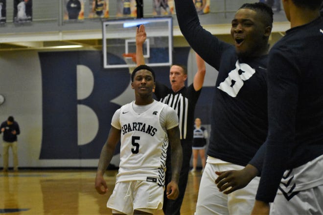 Battle guard Tay Patrick (5) smiles as the bench erupts after he made a 3-point shot during the Spartans' win over Father Tolton 63-61 on January 18, 2023, at Battle High School.