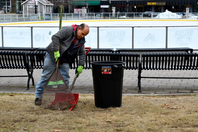 Worcester Department of Public Works and Parks employee Hermes Rivera uses a rake and snow shovel to clear leaves Thursday around the city Common Oval ice rink.