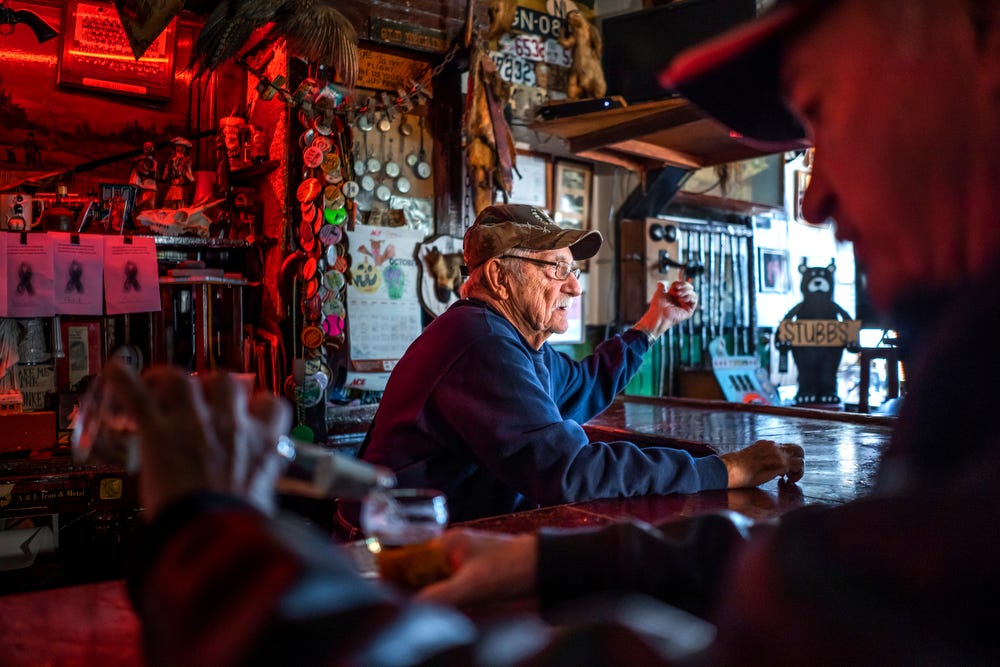Mike Guzek, of Ontonagon, pours his beer into a glass while spending the morning with his best friend, Stubb's Museum Bar owner Elmer Marks, center, on Thursday, Oct. 20, 2022.