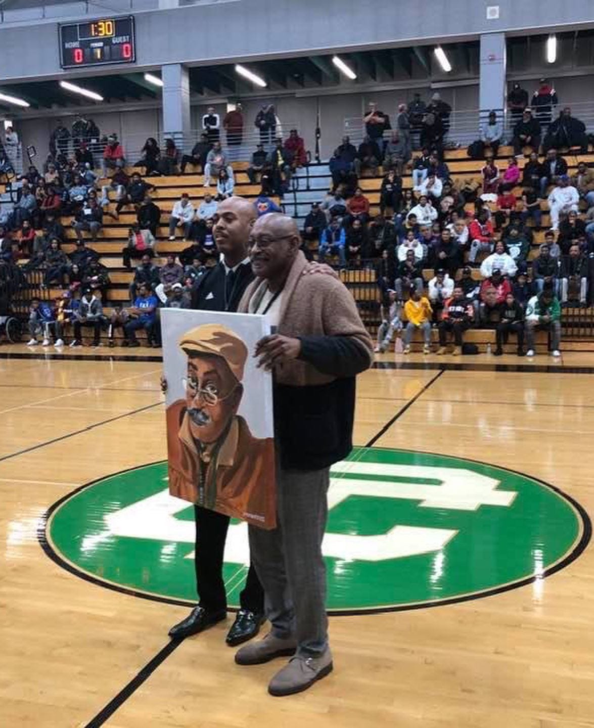 When Steve Hall (left) was a 10th grader on the varsity basketball team at Cass Technical High School, Willie (Roy) Ogletree recalls patiently answering questions that Hall had about the history of Cass Tech basketball, while driving Hall back to Cass following a game at Mumford High School.  More than 30 years later, on Dec. 27, 2019, Hall, now the boys basketball coach at Cass, showed his appreciation for Ogletree's continued support of the program by presenting him with a portrait of Ogletree created by John Baker III, who was Hall's teammate on the Cass basketball team.