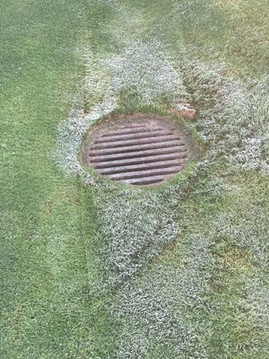 Frost lingers around a drain near the driving range at PGA West in La Quinta Thursday morning before the start of The American Express golf tournament